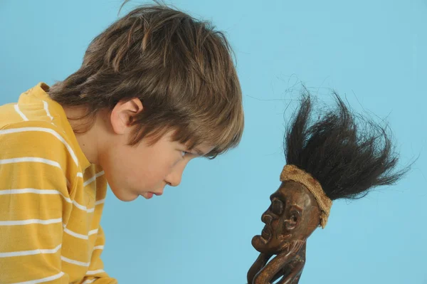 Jongen speelt met Afrikaanse masker — Stockfoto