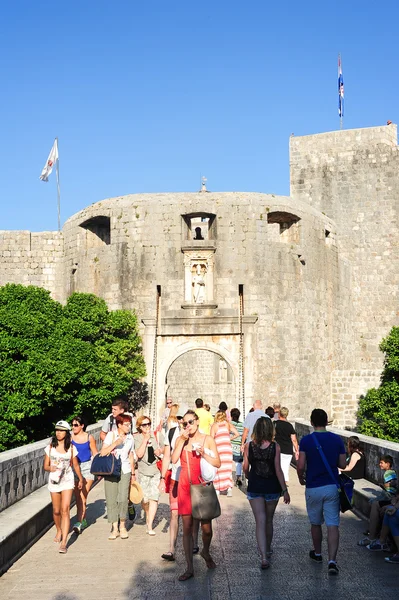 Los turistas que entran por la puerta principal de la ciudadela de Dubrovnik en — Foto de Stock