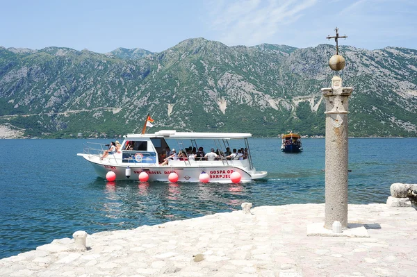 Tourists on a boat docking on the island of Lady of the rock — Stock Photo, Image