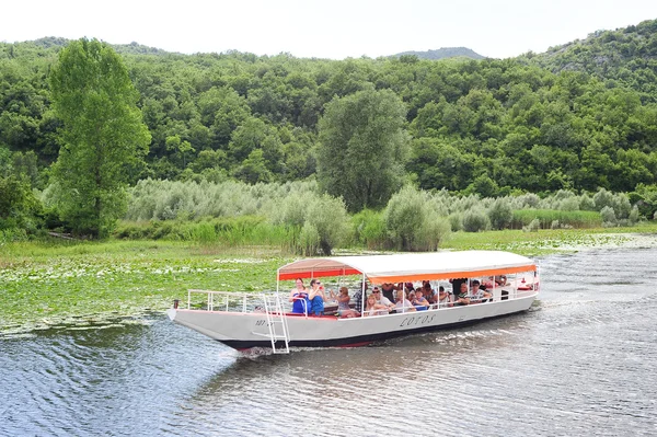 Turistas visitando el parque nacional del lago Skadar en un barco — Foto de Stock