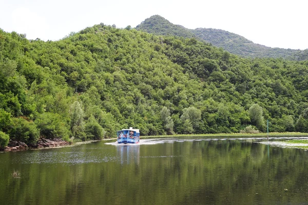 Turistas visitando el parque nacional del lago Skadar en un barco —  Fotos de Stock