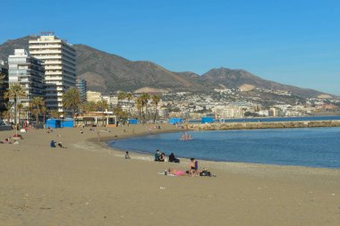 Fuengirola, İspanya - 30 Aralık 2020: İnsanlar İspanya 'da Fuengirola sahilinde güneşleniyor ve yüzüyorlar