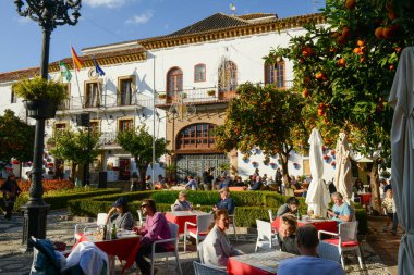 Marbella, İspanya - 5 Ocak 2022: İspanya 'da Marbella' daki belediye binasının önündeki bir restoranda içki içenler