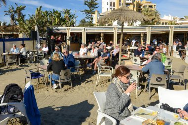 Cabopino, İspanya - 9 Ocak 2021: İspanya 'da Cabopino' da bir plaj restoranında yemek yiyen insanlar