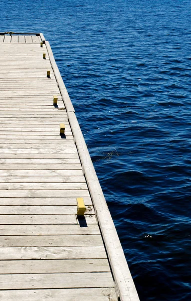 Doca de madeira em água azul — Fotografia de Stock