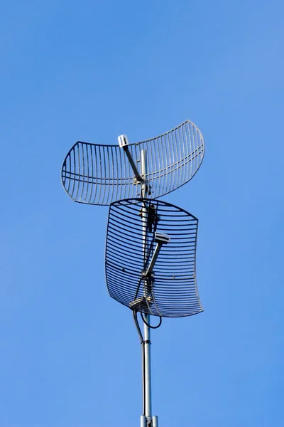 Two curved antennas on sky — Stock Photo, Image