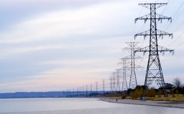 Wiersz elektryczne wieże oddala — Zdjęcie stockowe