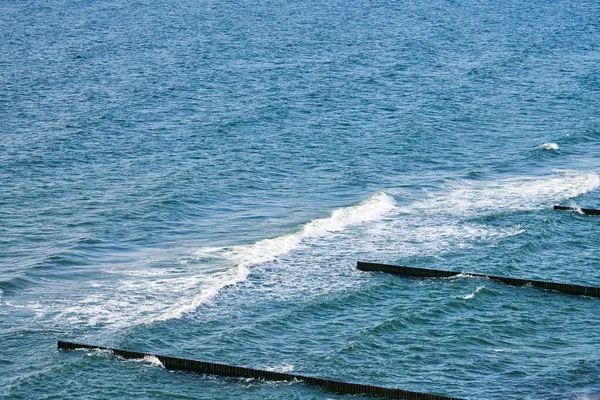 古色古香的木制腹股沟一直延伸到大海 远眺深蓝色的大海 波涛汹涌 海浪冲刷着防波堤 美丽的波罗的海风景 迷人的海景 — 图库照片