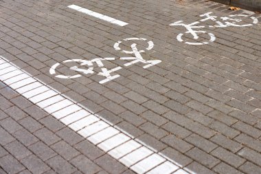 Two way cycle path, marking bike path on sidewalk, white painted bicycle sign on road on street. Bike road symbol. Ride on bicycle, cycling, bicycling, wheeling and healthy lifestyle concept clipart