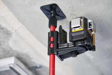 İnşaat alanında lazer seviyesinde ölçüm aleti, kapatın. Tamamlanmamış dairede ölçüm düzeyi. Ölçmek için profesyonel ekipman. İnşaat kalitesi