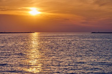 Gün batımı gökyüzü ve güzel manzaralı sakin bir deniz. İnanılmaz dramatik günbatımı gökyüzü çeşitli renkler ve yükselen güneşin renkleri ve suda yansıması. Meditasyon okyanusu, romantik sakin deniz manzarası