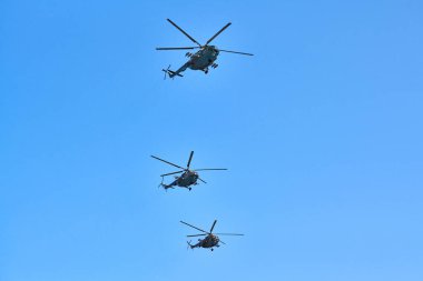 Gösteri uçuşunu gerçekleştirirken mavi gökyüzünde uçan üç askeri helikopter, kopyalama uzayı. Aerobatik takım hava gösterisinde uçuyor.