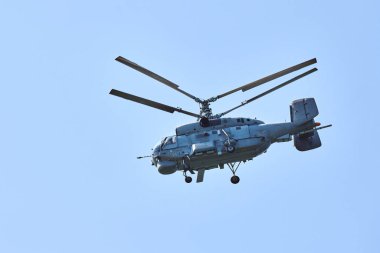 Donanma helikopteri parlak mavi gökyüzü arka planına doğru uçuyor, anlaşıldı. Denizaltı savaş karşıtı bir askeri helikopter denizaltı araması yapıyor.