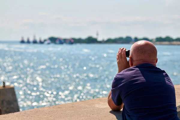 Літній Лисий Чоловік Стоїть Пірсі Дивиться Через Бінокль Військові Кораблі — стокове фото