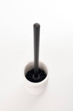 Modern beyaz taş tutacağındaki siyah tuvalet fırçası izole edilmiş beyaz arka plan. Tuvalet temizleme için tuvalet aleti. Tuvalet temizleyicisi ve çamaşır suyu için fırça.