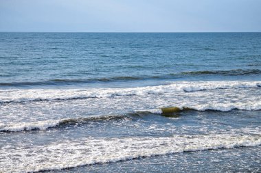 Derin mavi deniz suları köpüklü dalgalarla sıçrıyor. Okyanus manzarası, su sıçratan dalgalar, beyaz köpüklü koyu mavi dalgalı deniz suları. Su yüzeyi, doğal arkaplan, kopyalama alanı