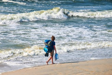 Deniz boyunca seyahat eden genç bir sırt çantalı kadın. Büyük mavi sırt çantalı kız gezgin yeni bir bölgeyi keşfediyor, güzel Baltık Denizi geçmişi var. Tek başına kadın seyahati