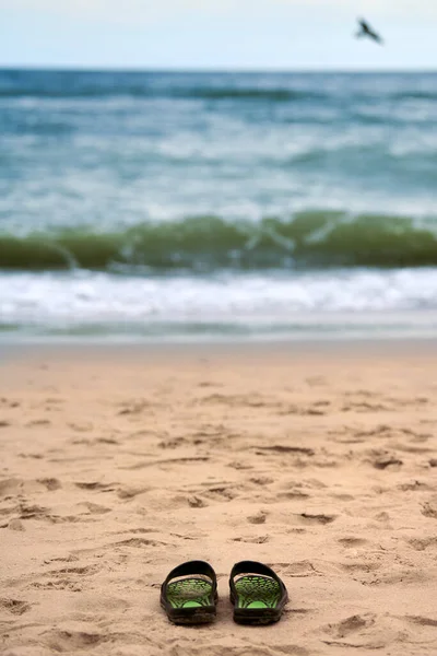 Sandały Piaszczystej Plaży Piękne Tło Morza Bałtyckiego Nikt Czarne Kapcie — Zdjęcie stockowe