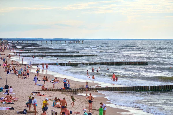 Zelenogradsk, Rusya - 07.30. 2021 - Turistlerle dolu umumi kumlu plaj. Baltık Denizi kıyısında yaz turizm sezonu. İnsanlar plajda dinleniyor ve ılık mavi denizde yüzüyorlar.
