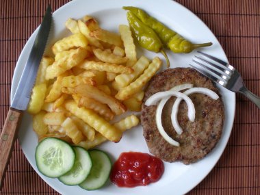 hamburger ve patates kızartması yemek beyaz bir plaka üzerinde.