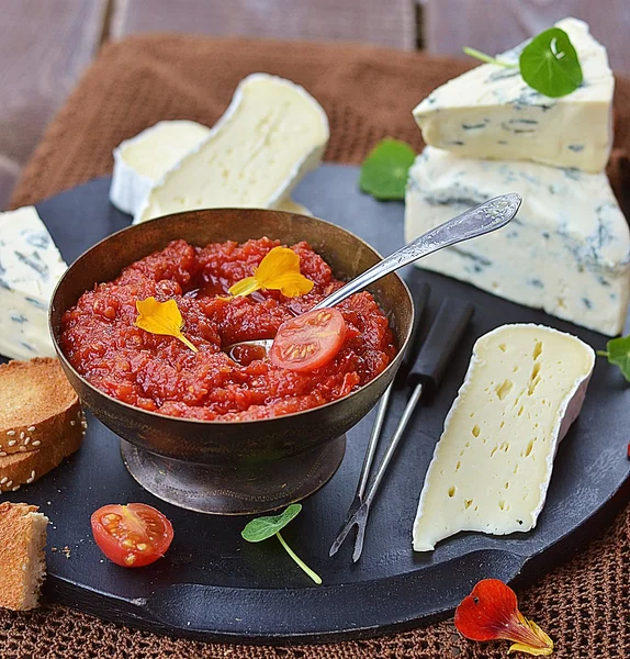 Cheese plate with tomato chutney — Stock Photo, Image