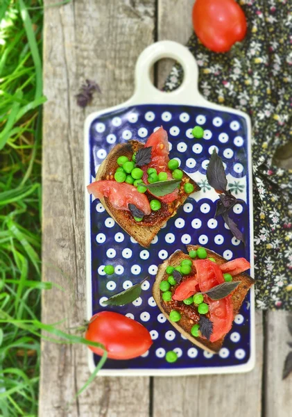 Bruschetta con tomate maduro y seco y guisante verde —  Fotos de Stock