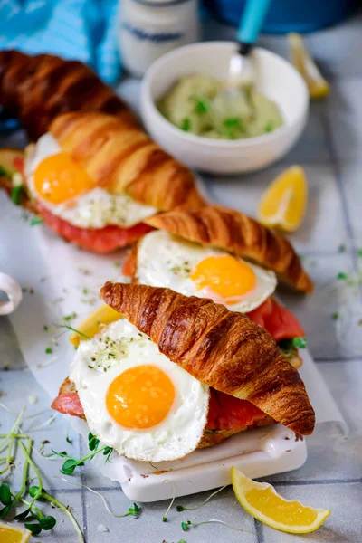 サーモンと揚げ卵を朝食にクロワッサン 健康的な食前酒 選択的焦点 — ストック写真