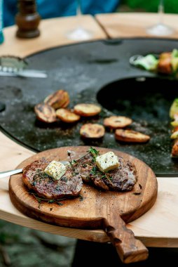 Izgarada patates ve tereyağlı biftek. Açık hava fotoğrafı. Seçici odak noktası.