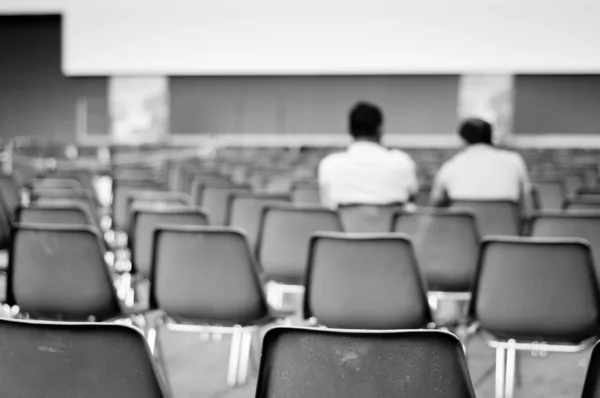 Mannen zitten op lege stoelen — Stockfoto