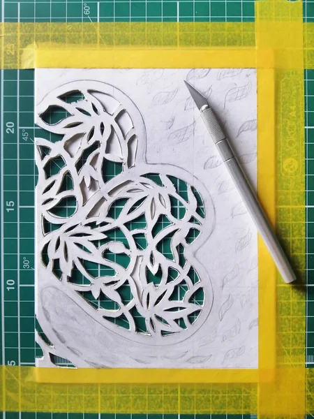 Paper cutting of green clover shamrock process, made by hand. Openwork with Irish plant leaves papercraft art, step by step workshop. Flat top view.