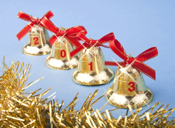 Navidad campanas de oro y cinta roja — Foto de Stock