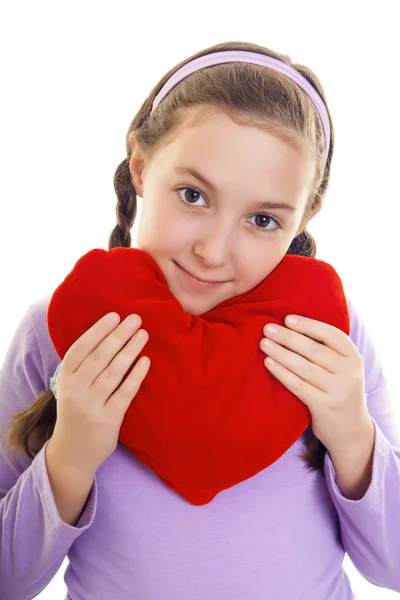 Girl holding a heart shaped pillow in her arms — Stock Photo, Image