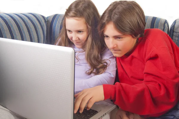 Hermano y hermana jugando juegos en el portátil — Foto de Stock