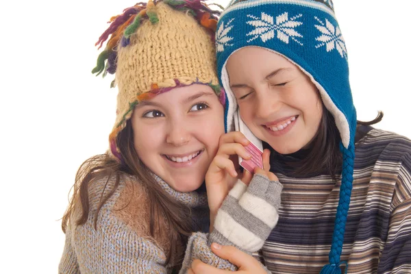 Красивые молодые девушки в теплой зимней одежде разговаривают на мобиле — стоковое фото