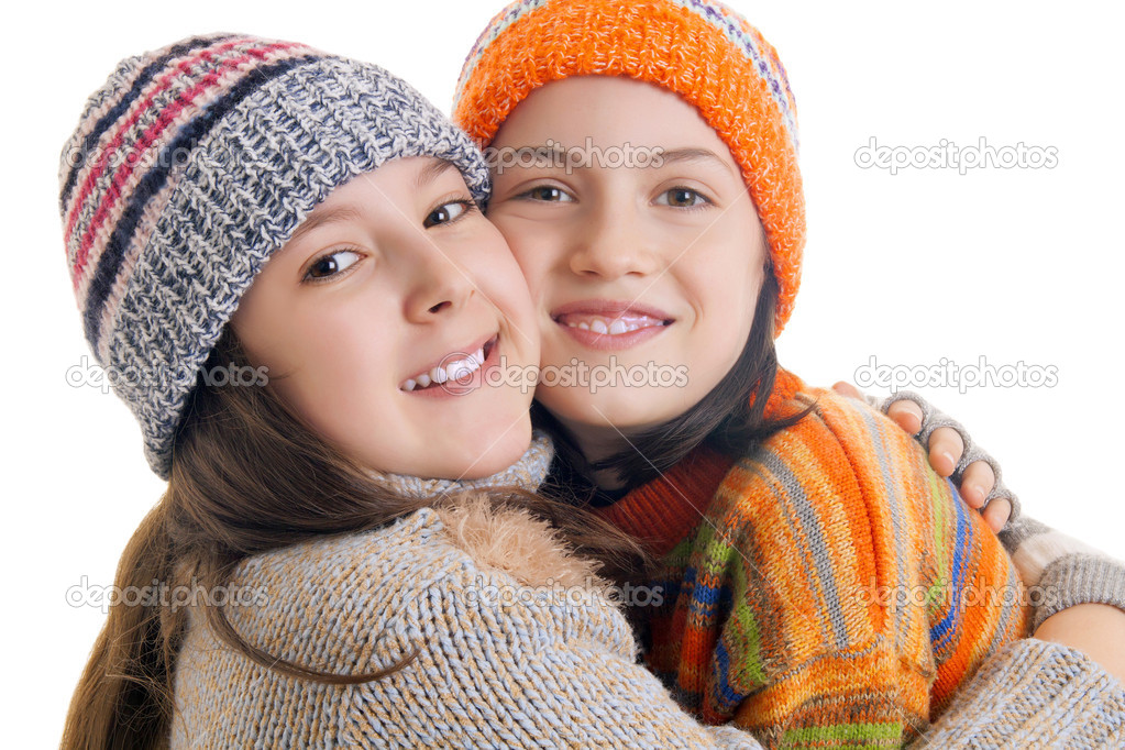 Beautiful young girls in warm winter clothes hugging