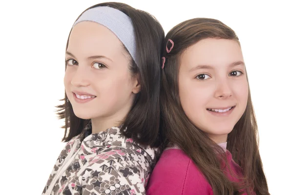 Two young girls back to back smiling — Stock Photo, Image