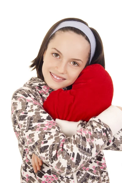 Bella ragazza abbracciando cuscino a forma di cuore — Foto Stock