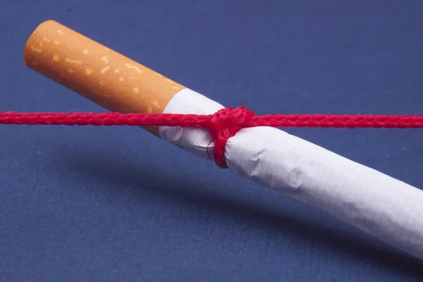 Sigaret vastgebonden met rode koord — Stockfoto