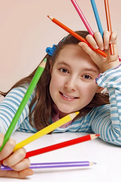 Улыбающаяся девушка держит цветные карандаши — стоковое фото
