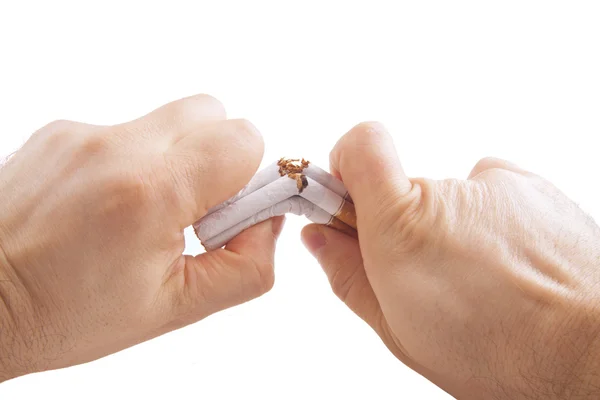 Human hands breaking stack of cigarettes — Stock Photo, Image