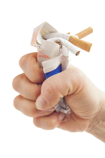 Poing humain cassant paquet de cigarettes sur fond blanc — Photo