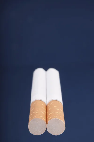 Deux cigarettes sur fond bleu — Photo