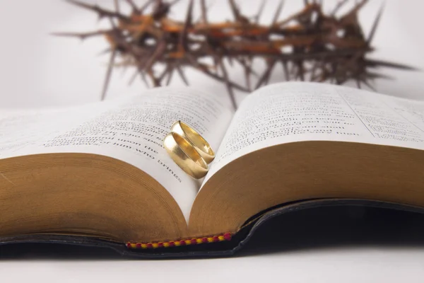 Eheringe auf heiliger Bibel und Dornenkrone — Stockfoto