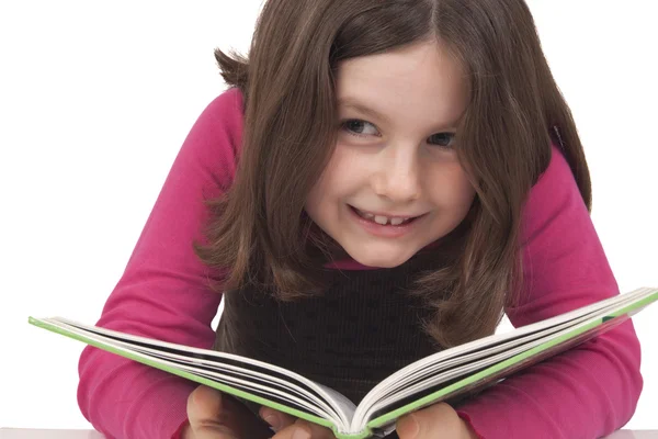 Beautiful little girl reading a book and smiling — Stock Photo, Image