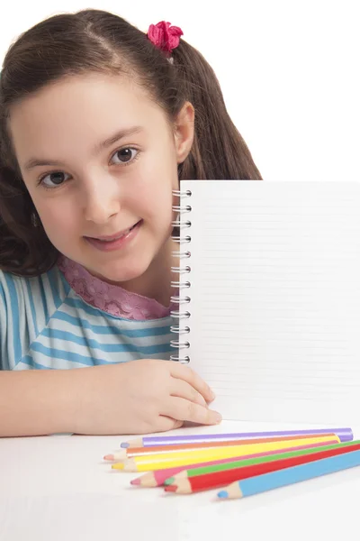 Beautiful little girl showing empty space on notebook — Stock Photo, Image