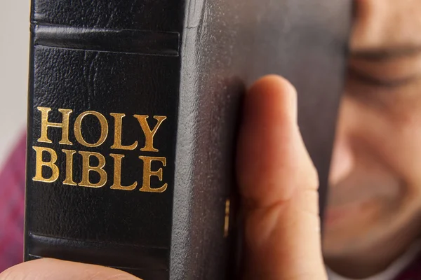 El hombre orando sosteniendo la Biblia — Foto de Stock