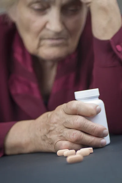 Mãos de mulher deformada de artrite reumatoide segurando pílulas — Fotografia de Stock