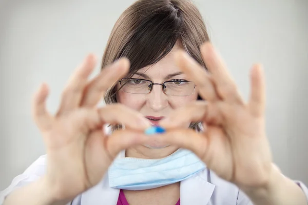 Doctora mujer sosteniendo cápsula azul —  Fotos de Stock