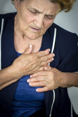 Yaşlı kadın göğüs ağrısı çekiyor.
