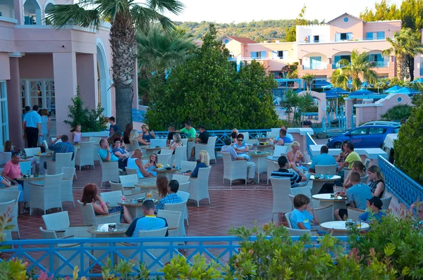 ISLA DE RHODES, GRECIA - 1 DE JULIO: Los turistas toman sus bebidas en un restaurante del hotel Mitsis Rhodos Village el 1 de julio de 2013. Isla de Rodas, Grecia . — Foto de Stock